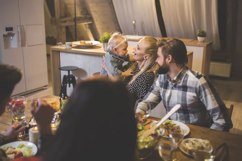 Family sitting down to dinner together, at ease